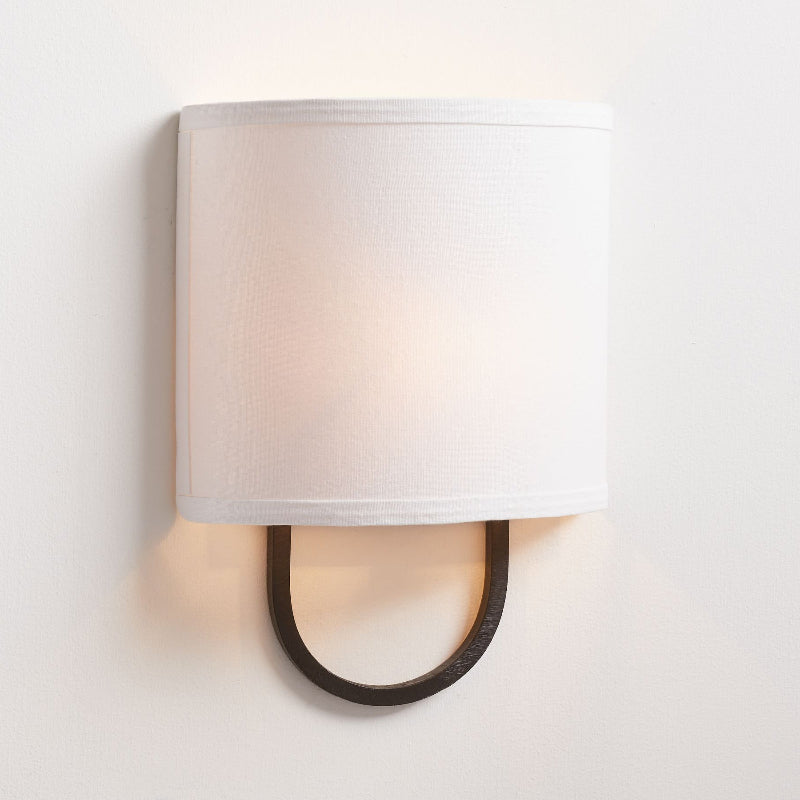 Lifestyle image of the Atticus Wall Lamp installed in a bedroom.