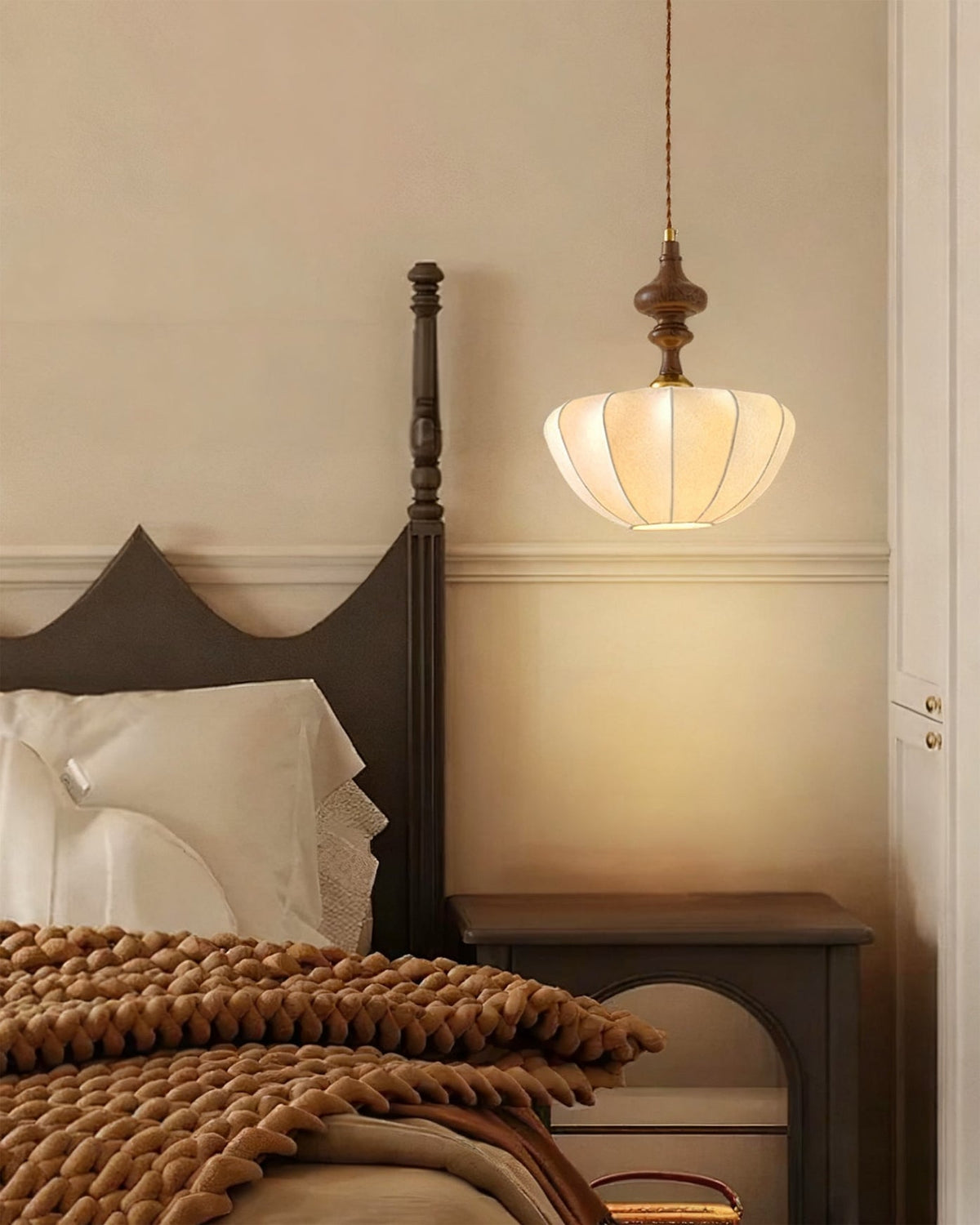 Detail shot of the carved wood-toned top piece of the pendant light.