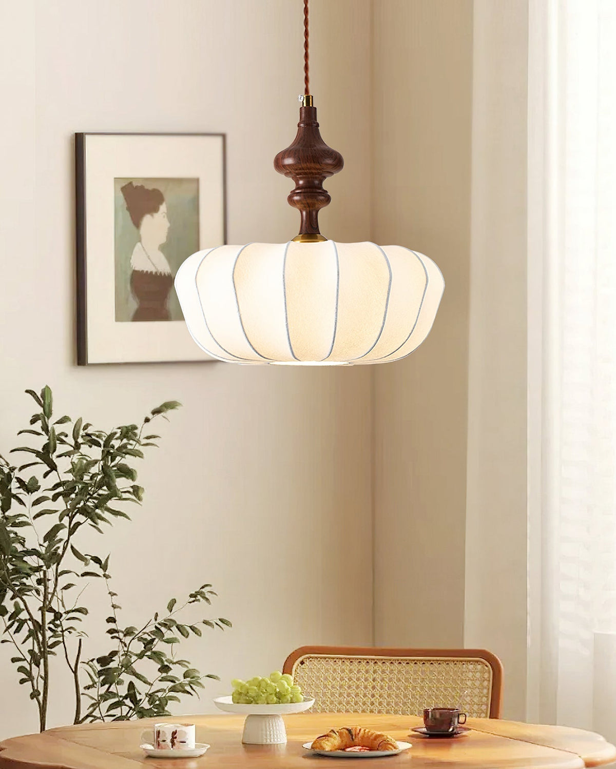 The Baird Pendant Light hanging over a dining table, casting a warm glow.