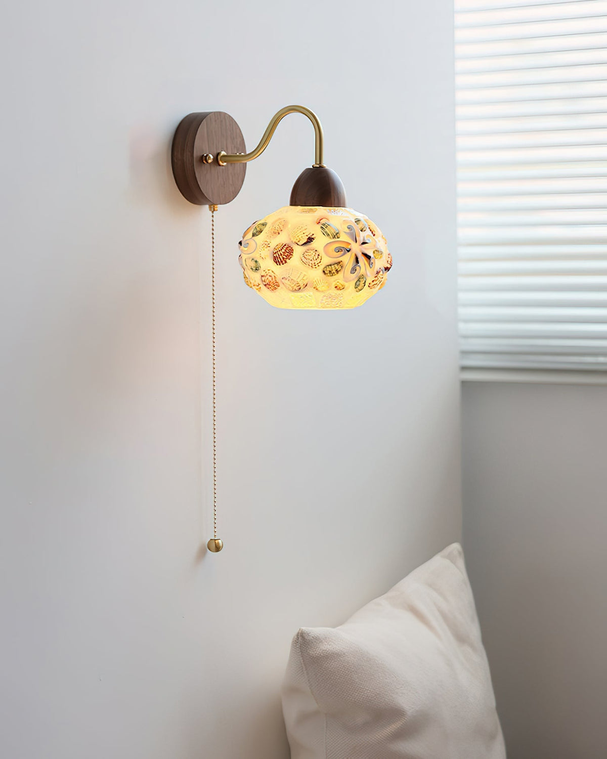 Detail shot of the walnut-colored wood mounting plate and brass fixture.