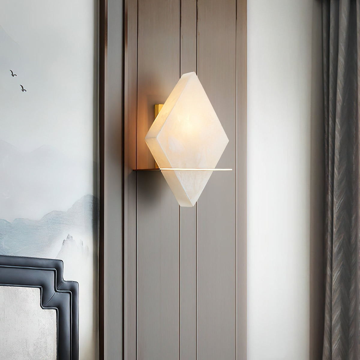 The Brockton Wall Lamp illuminated, showing its warm glow through the alabaster.