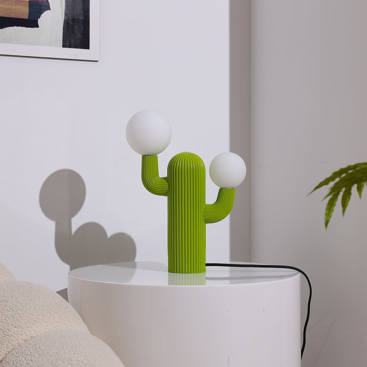 The Cactus Table Lamp illuminated, casting a warm glow.