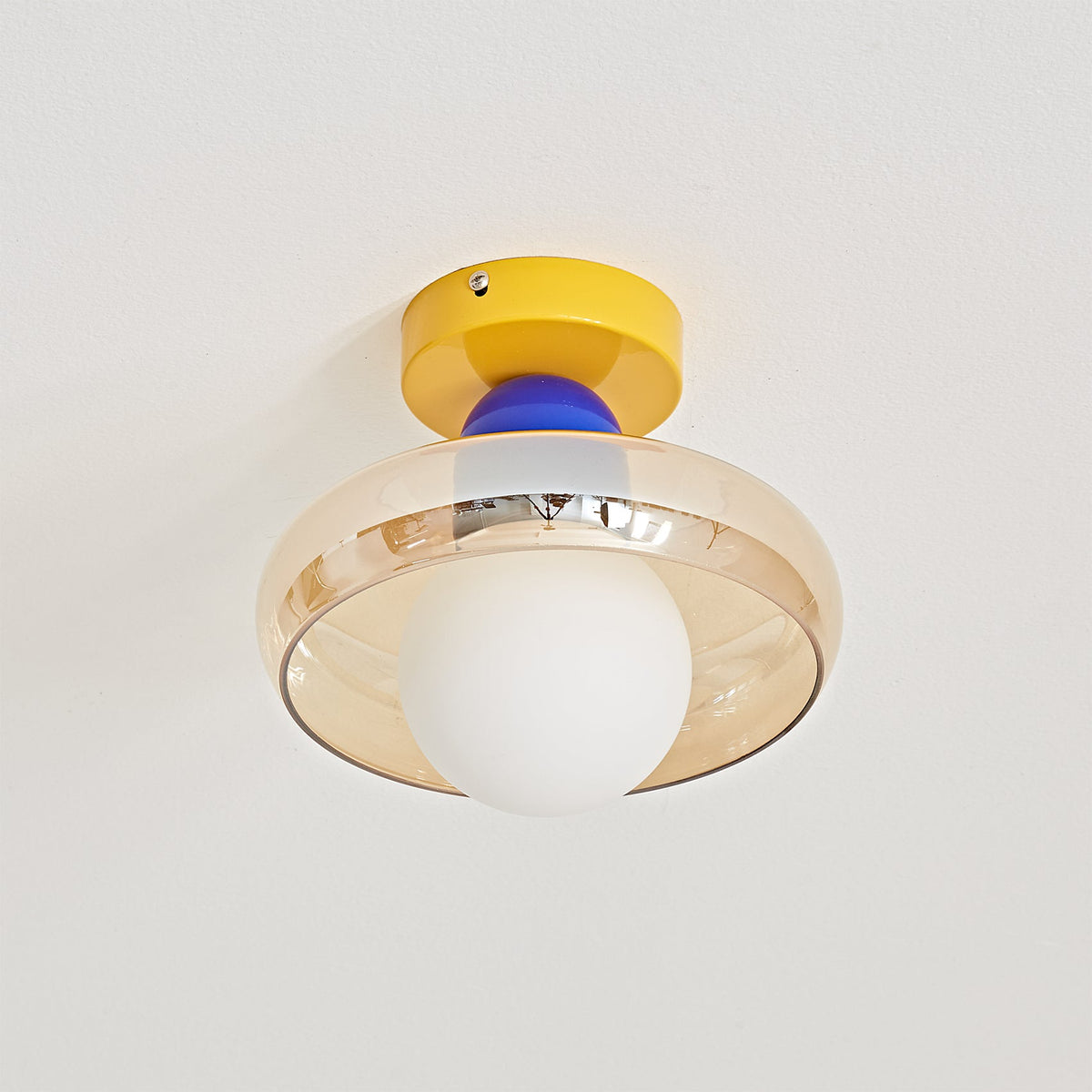 The Alabax Ceiling Light in red, shown against a dark wall for contrast.
