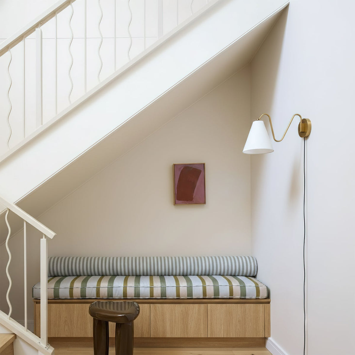The two-head Cleome wall lamp installed in a living room above a side table.