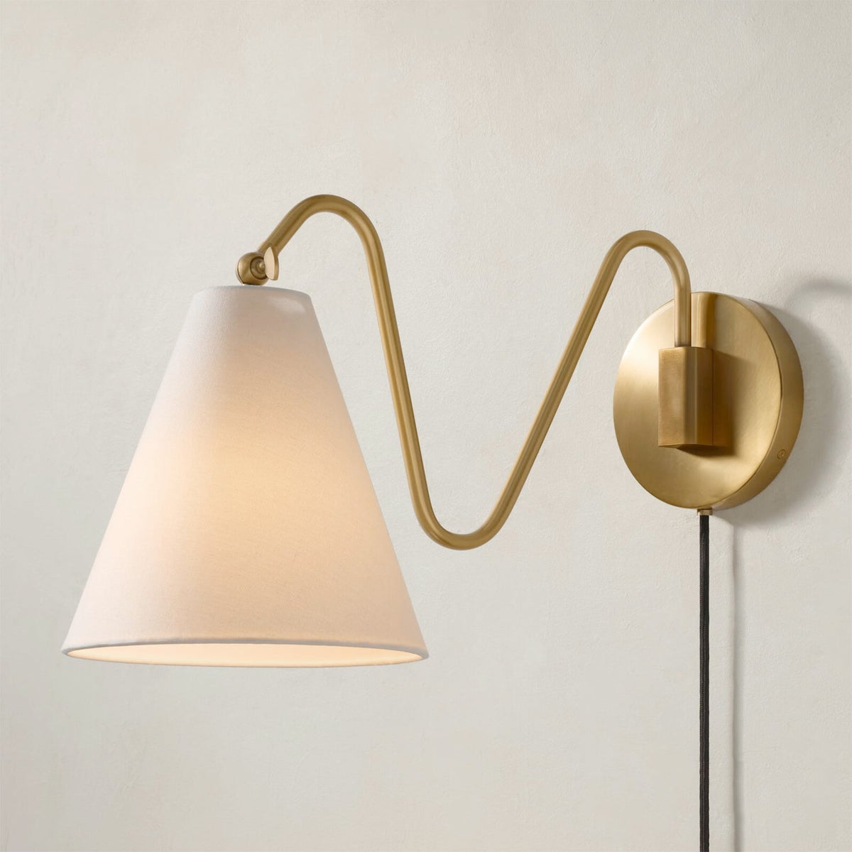 Angled view of the one-head Cleome wall lamp in brass.