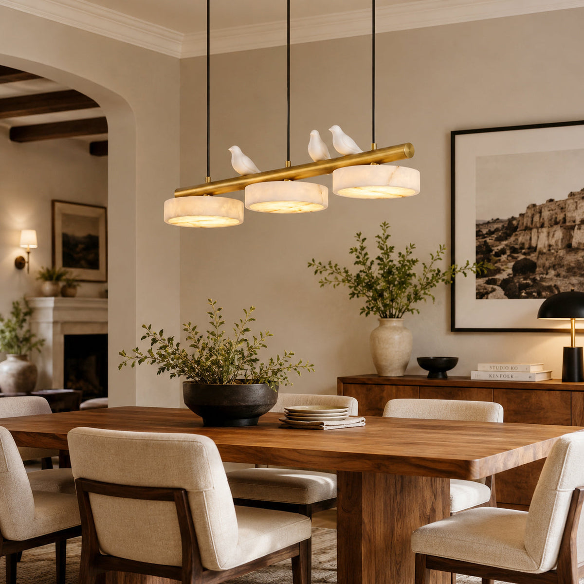 Close-up of the sculpted alabaster bird and glowing disc on the Sienna chandelier.