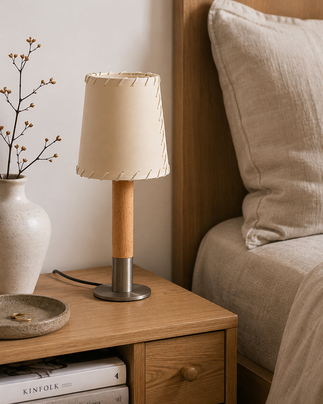 Kove Parchment Table Lamp used as a nightstand light in a bedroom.