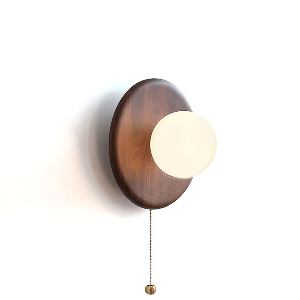 Front view of the Abel wood disk wall light showing the walnut base and white glass shade.