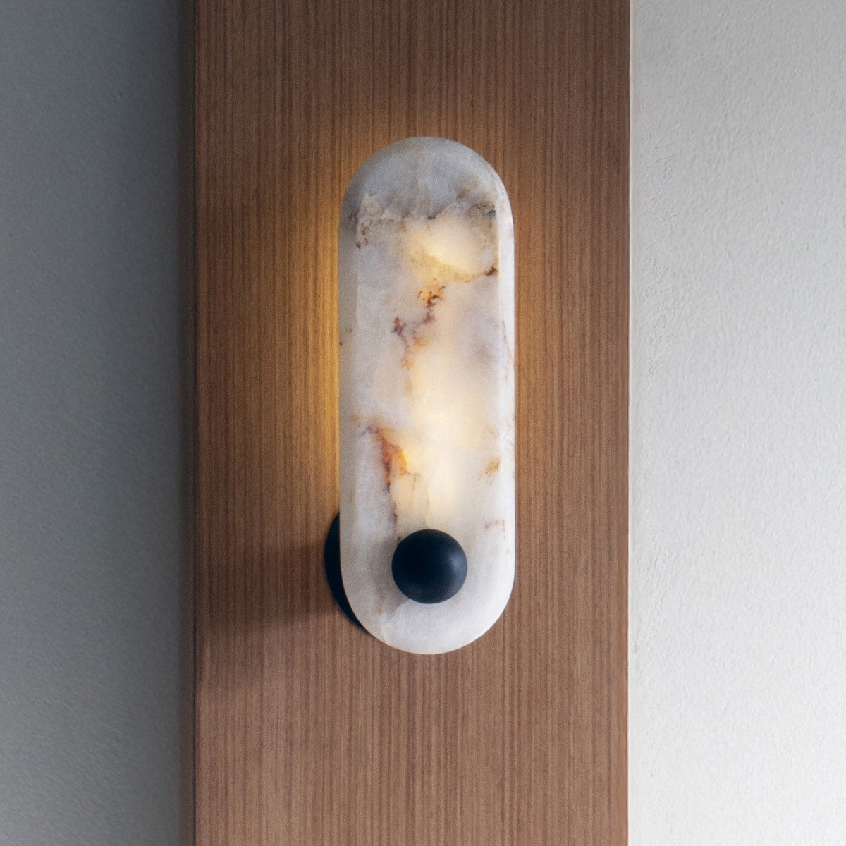 A pair of Breuer Alabaster Wall Sconces installed on either side of a piece of art.