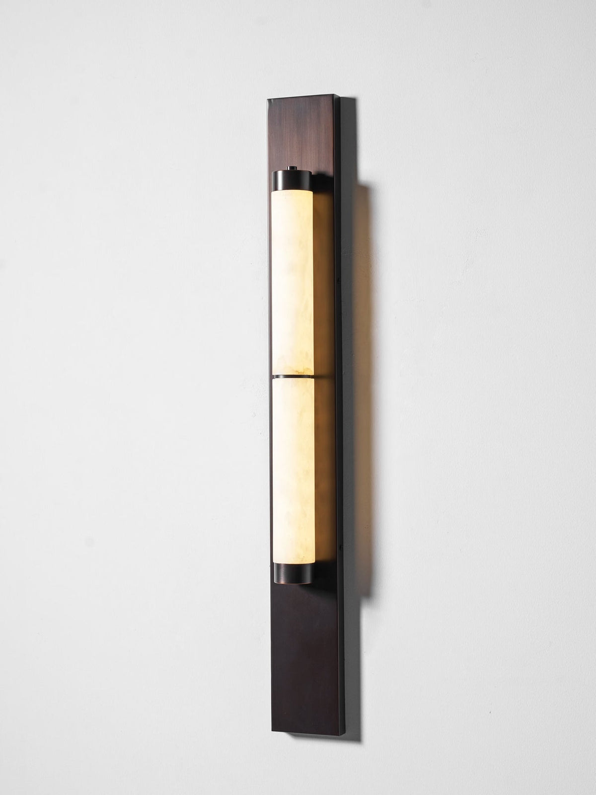 The wall lamp casting a soft, warm light.
