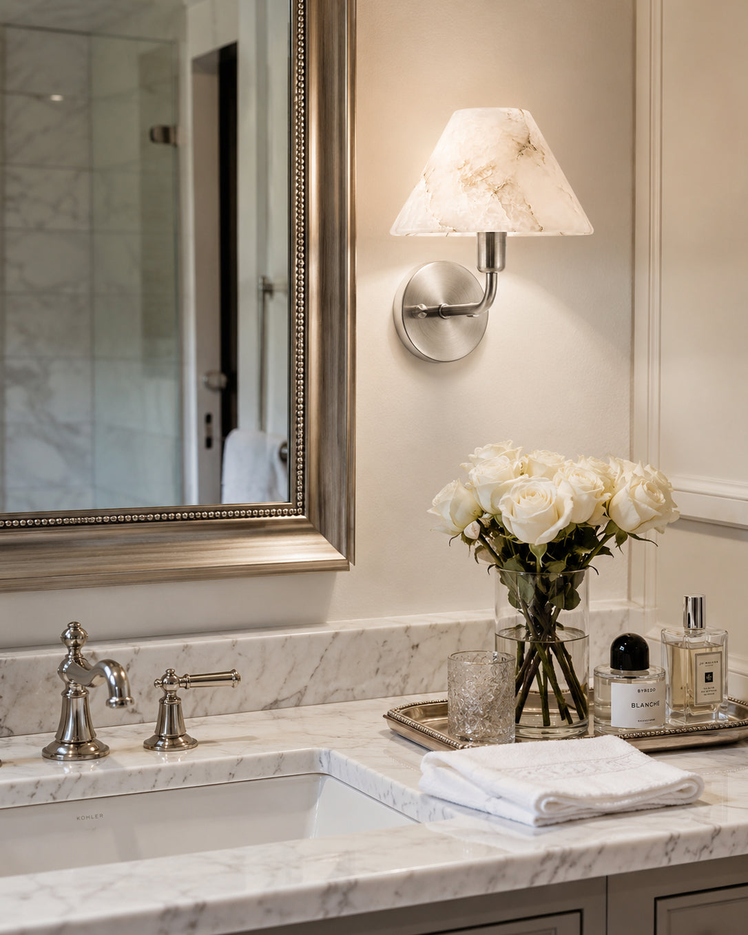 Gilda Wall Sconce illuminated, showing the warm glow through the stone.