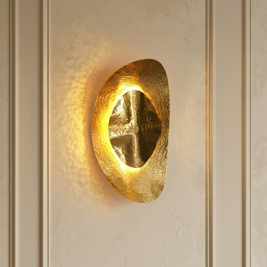 Close-up view of the hand-hammered texture on the brass surface of the Helios sconce.