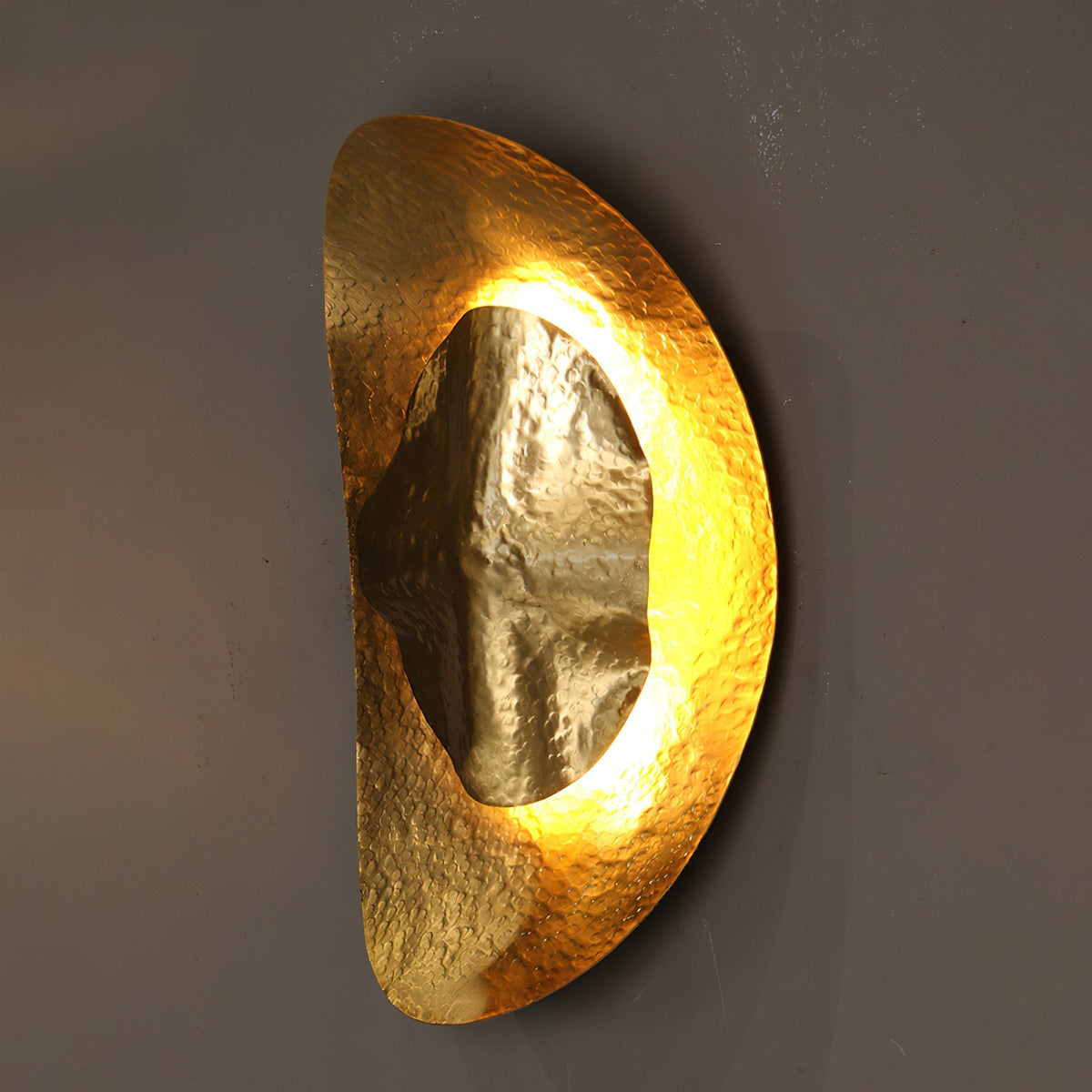 The Helios sconce casting a warm, ambient glow upwards against a dark wall.