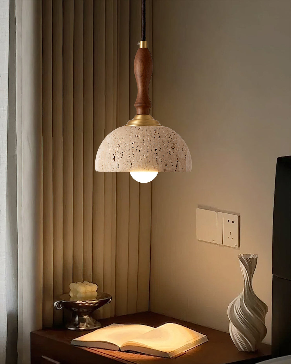 A single Enora pendant light providing ambient light next to a bed.