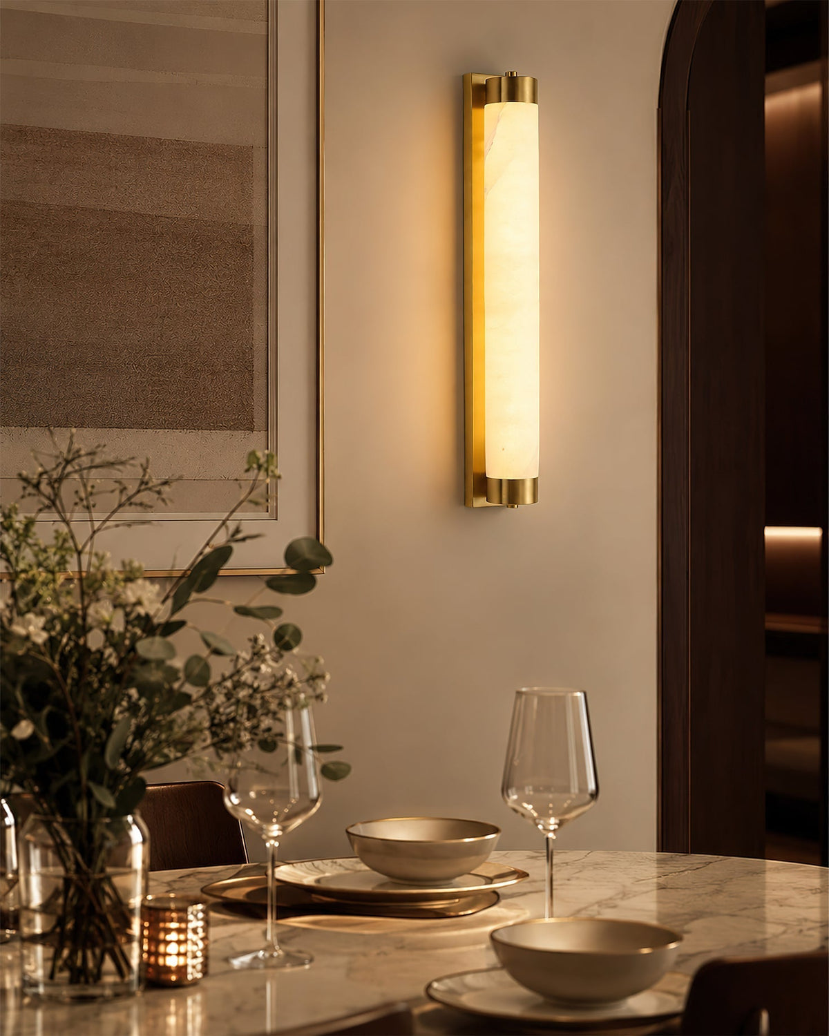 The Langham Alabaster Wall Sconce illuminated, casting a warm, ambient glow.