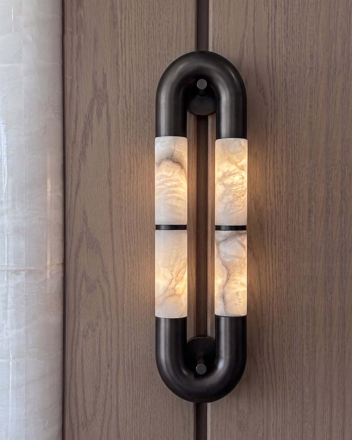 The black Mirabelle sconce installed on a living room accent wall.
