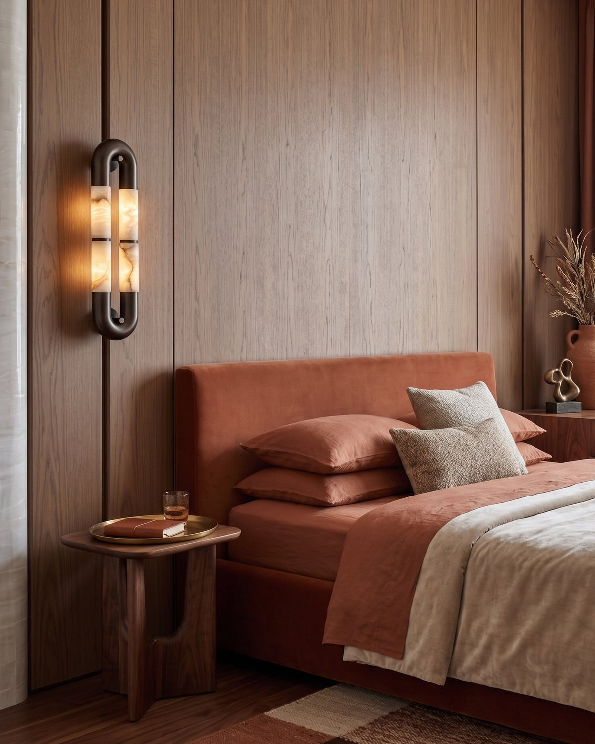 Angled view of the black Mirabelle wall sconce against a light wall.