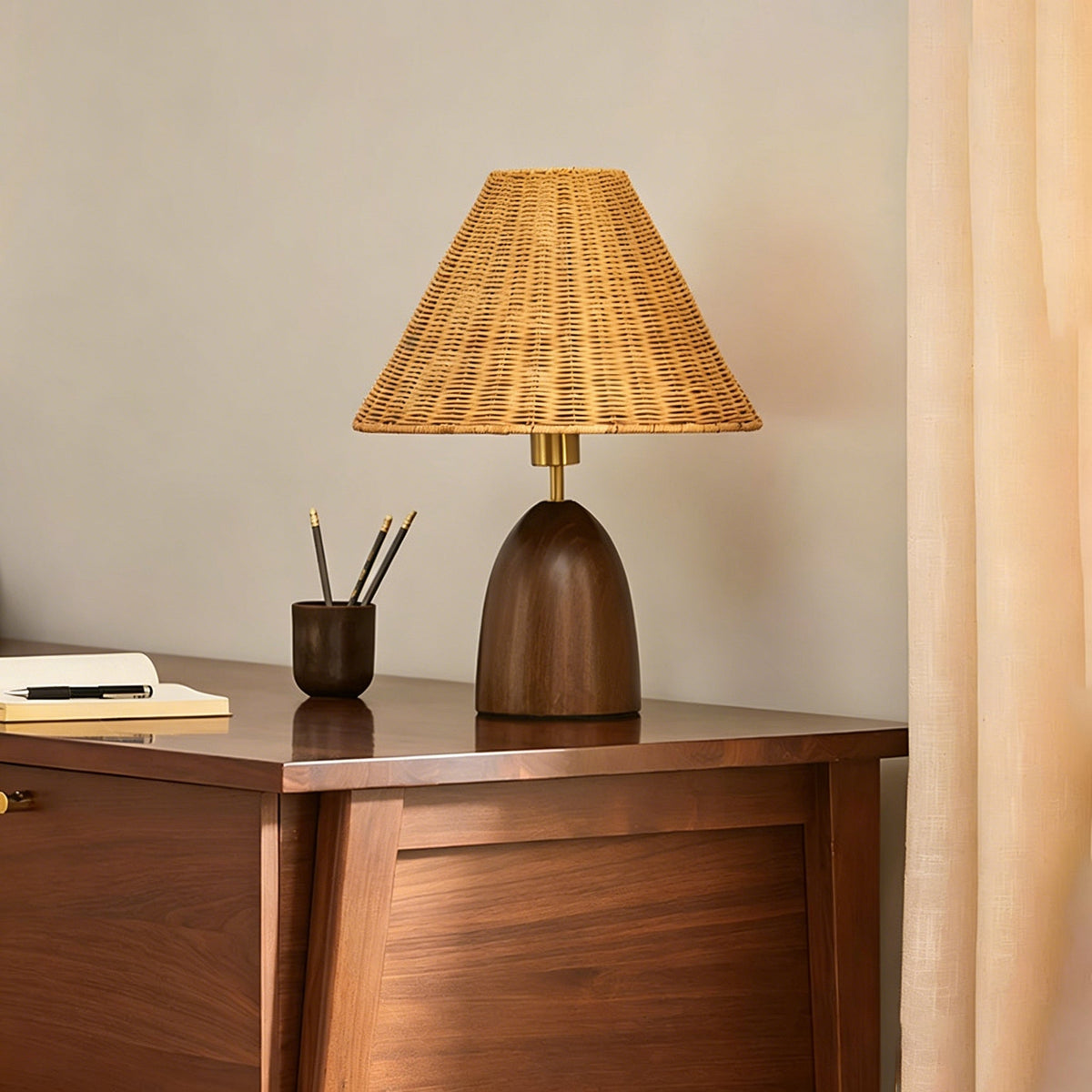The Suri Rattan Table Lamp shown on a side table in a living room setting.