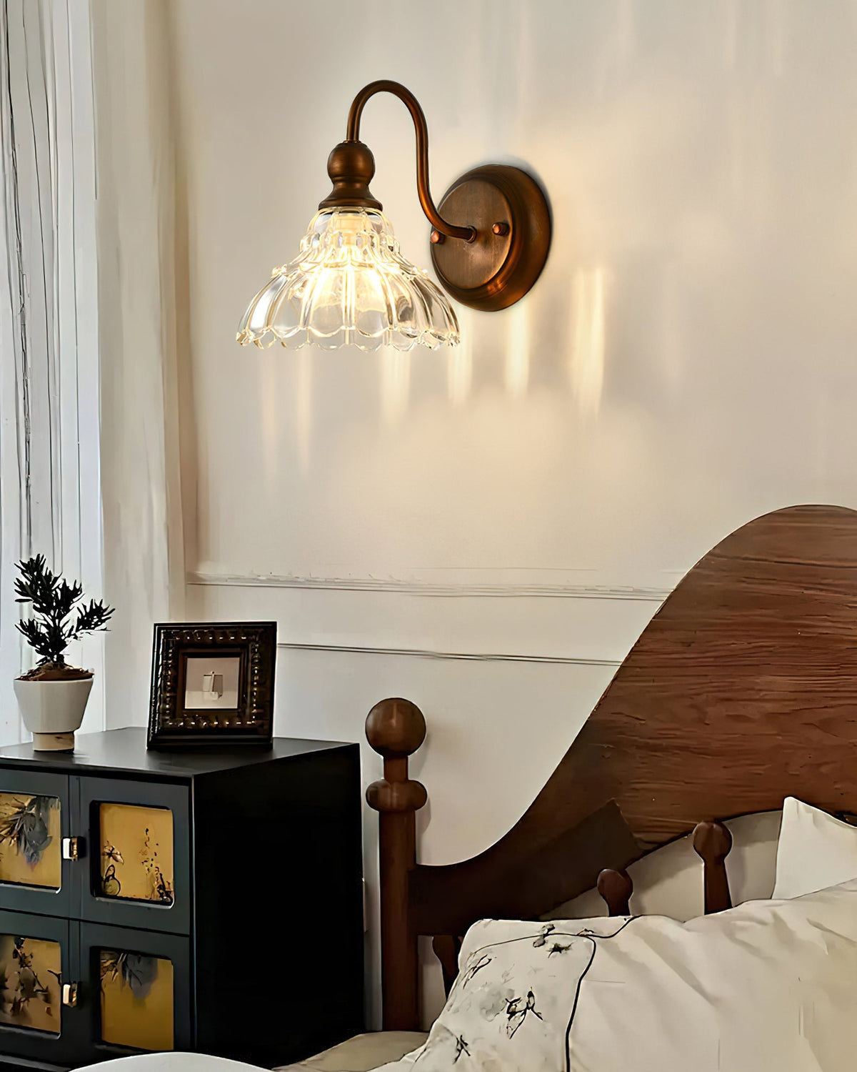 Sutton Glass Wall Sconce installed in a traditional bathroom setting above a sink.