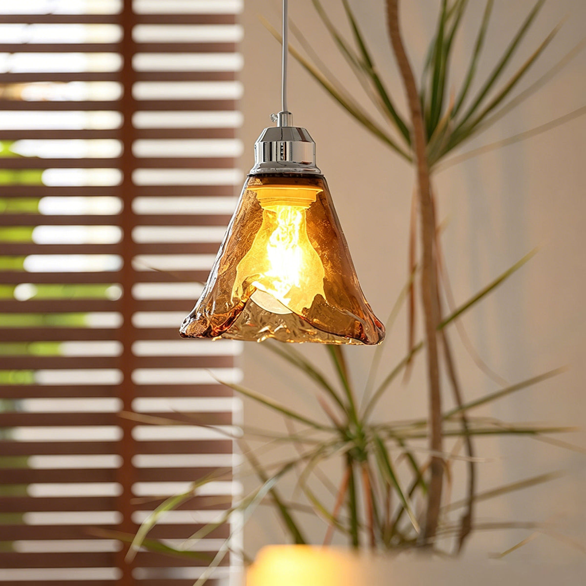 Three-head Tiro Glass Pendant Light hanging above a modern dining table.