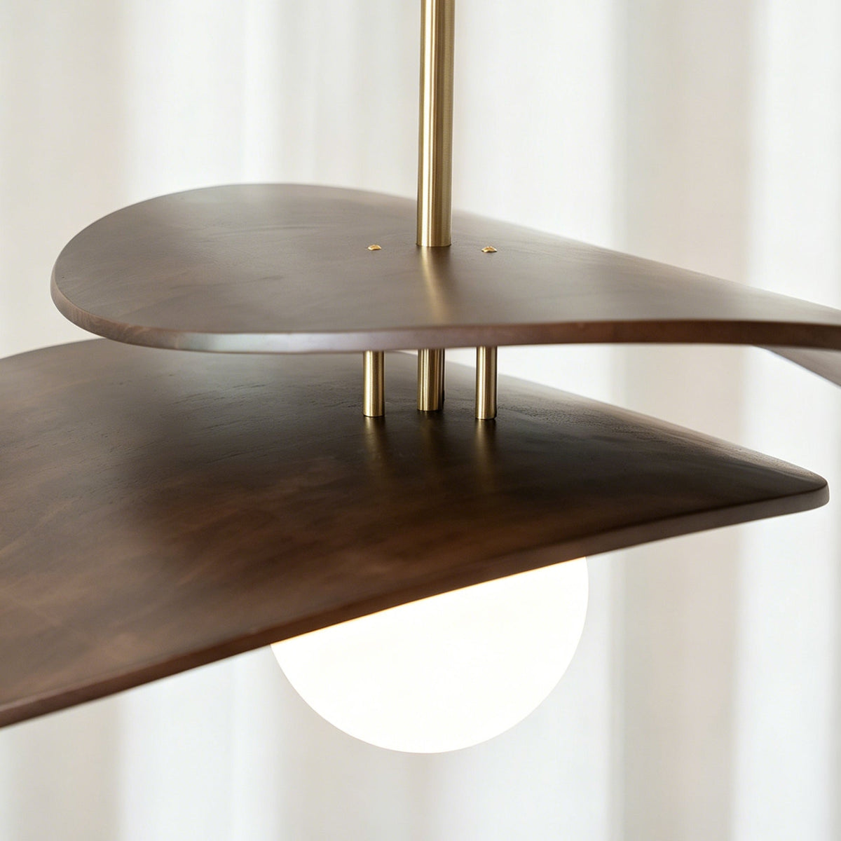 Side profile of the Zane walnut pendant light showing its sculptural form.