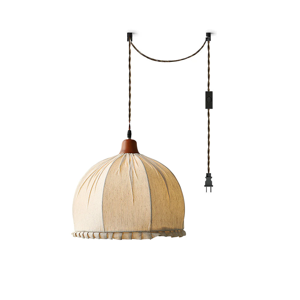 Dippa Swag Pendant Light with a beige fabric shade and wood cap against a neutral wall.