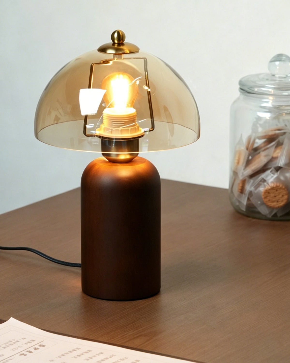 The Disko Table Lamp illuminated, casting a honey-toned glow in a dark room.