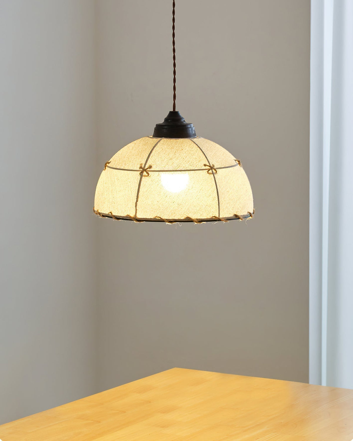 The two-light Duomo Pendant illuminating a boho-style living room.