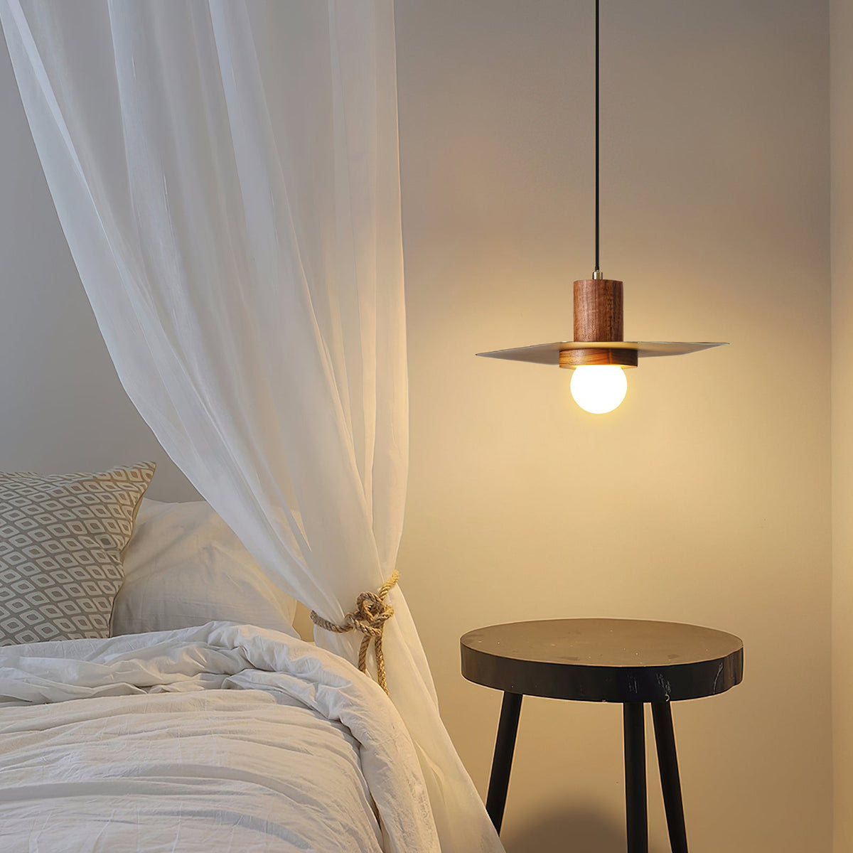 Close-up of the Elara Pendant Lamp's white globe bulb and brass fixture.