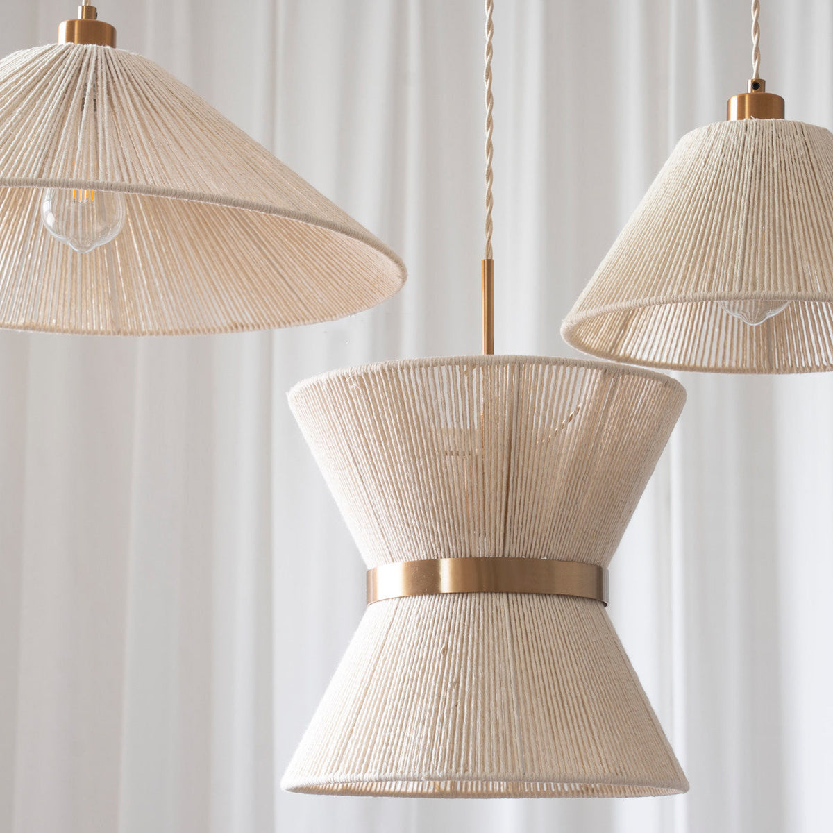 A pair of Elara Woven Pendant Lights hanging elegantly over a wooden dining table.