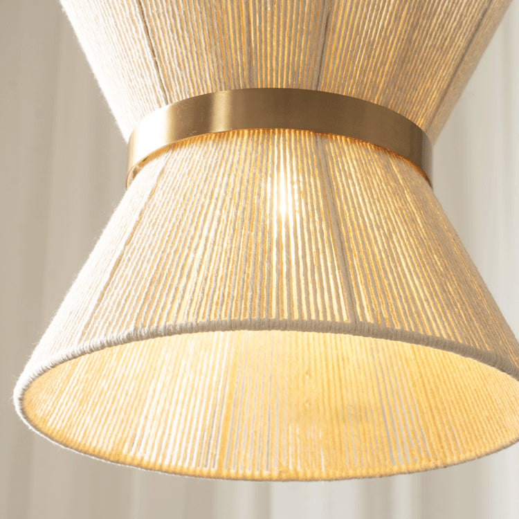 The hourglass model of the Elara pendant light in a cozy reading nook.