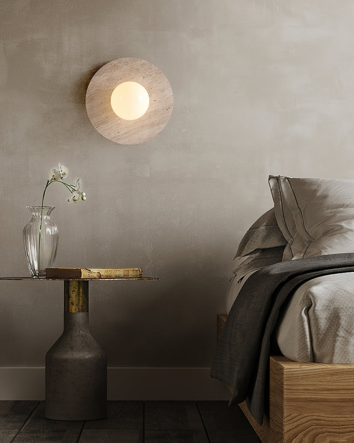 Angled view of the Elira Travertine Wall Lamp, showing its sculptural form.