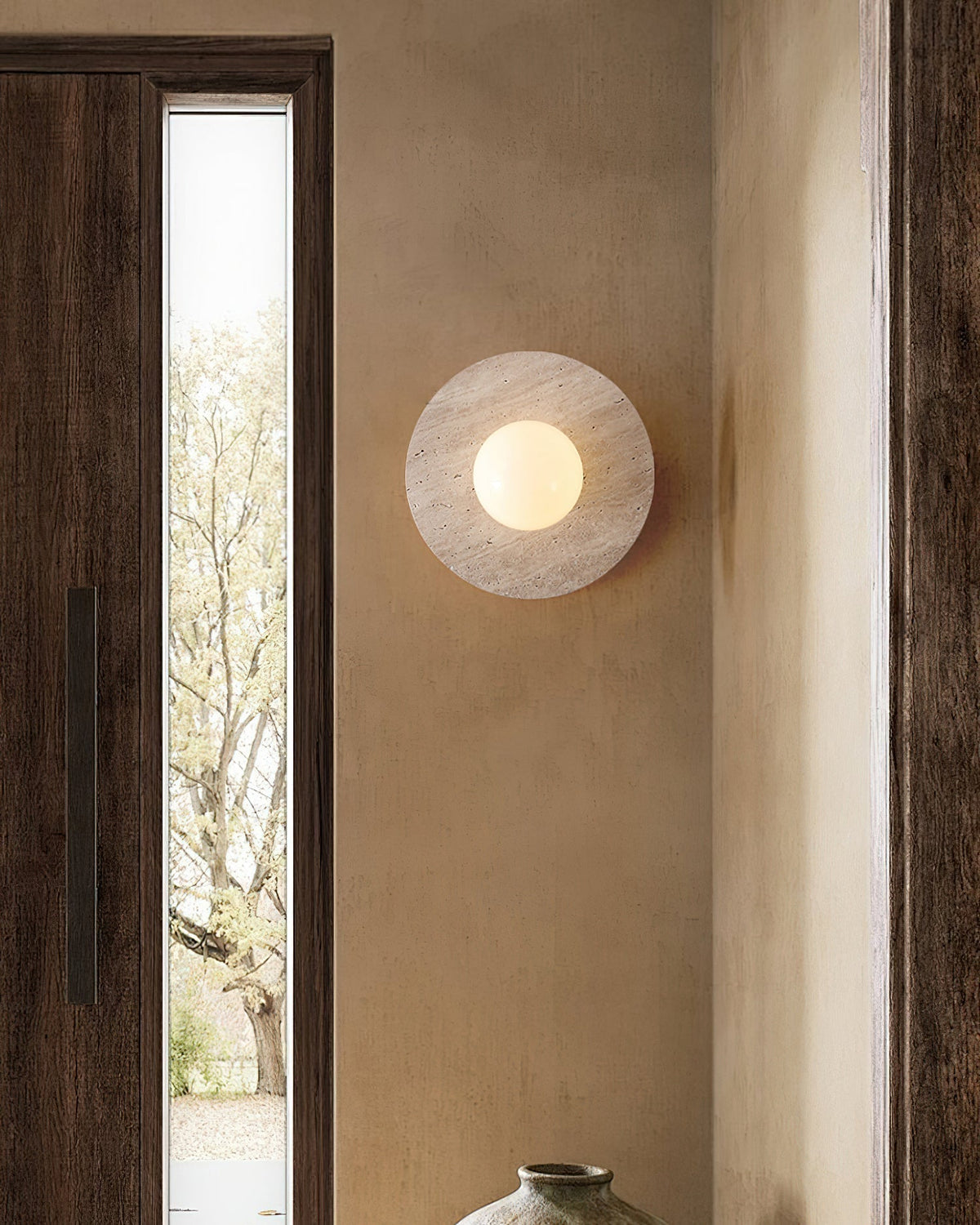 Elira Travertine Wall Lamp illuminating a modern living room.