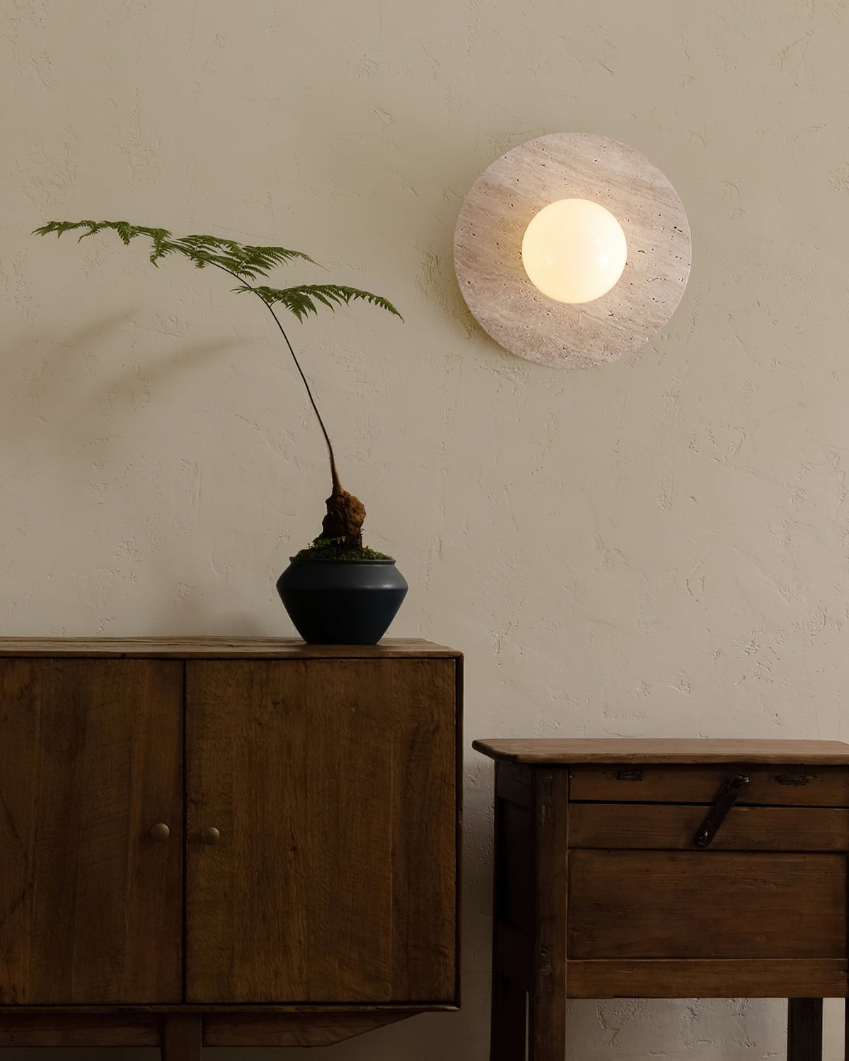Elira Travertine Wall Lamp shown mounted on a light-colored wall.