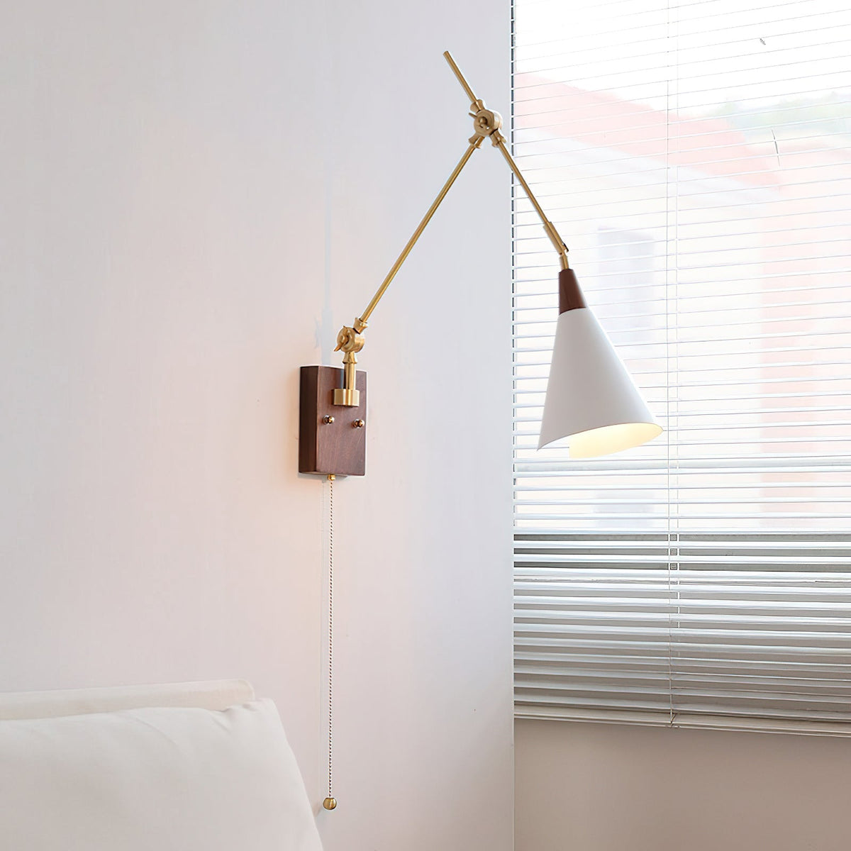 Close-up of the Fleka Wall Lamp's wood and brass articulating arm.