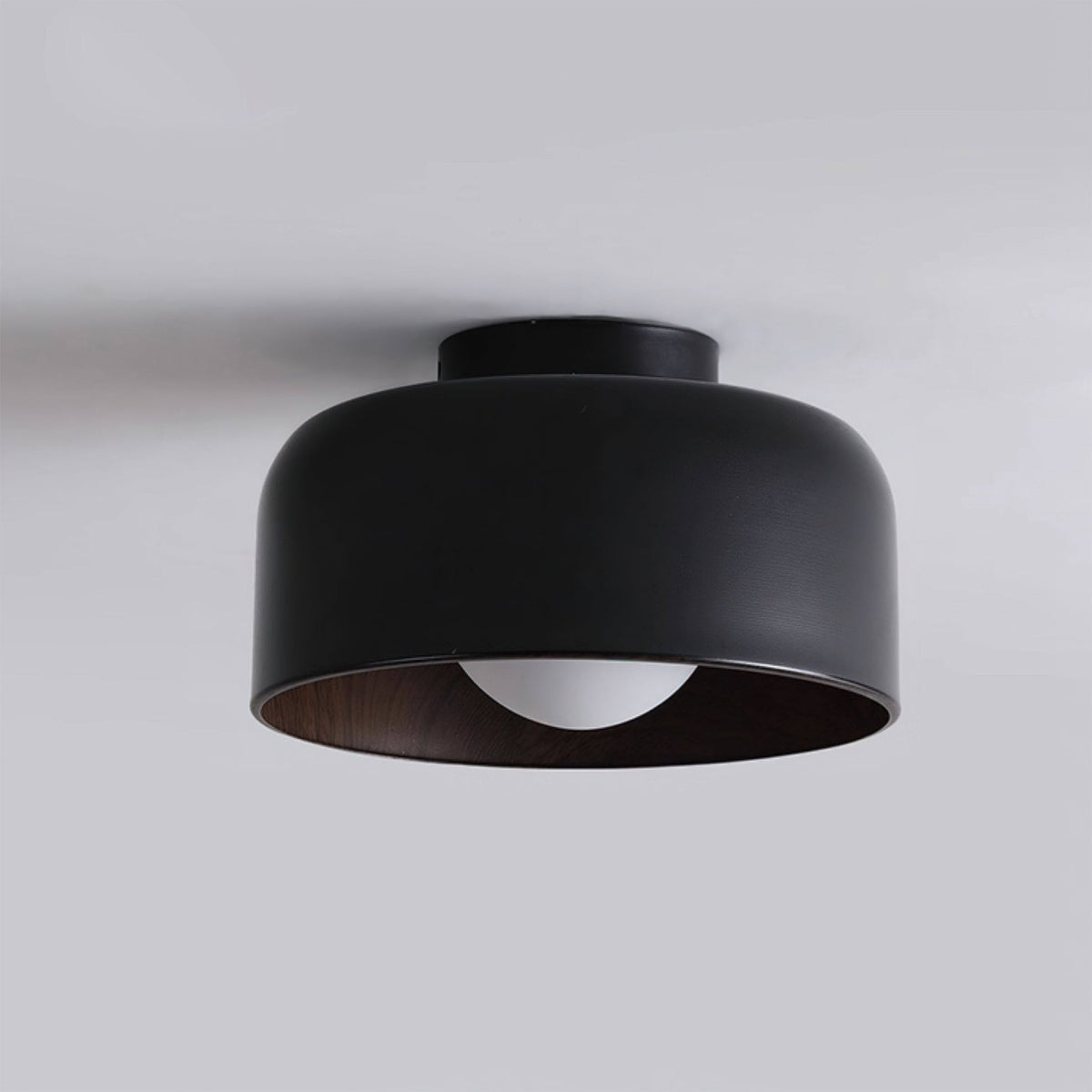 Lifestyle image of the Folkio Ceiling Light in a minimalist bedroom.