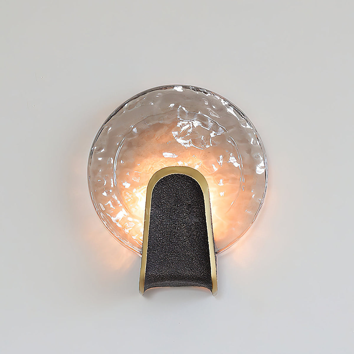 The amber glass Ingot Wall Lamp against a light-colored wall.