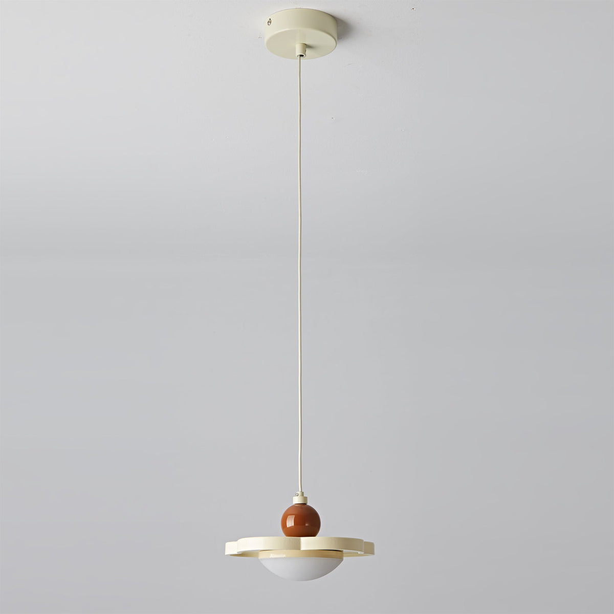 The pink Laguna Pendant Light against a neutral wall.