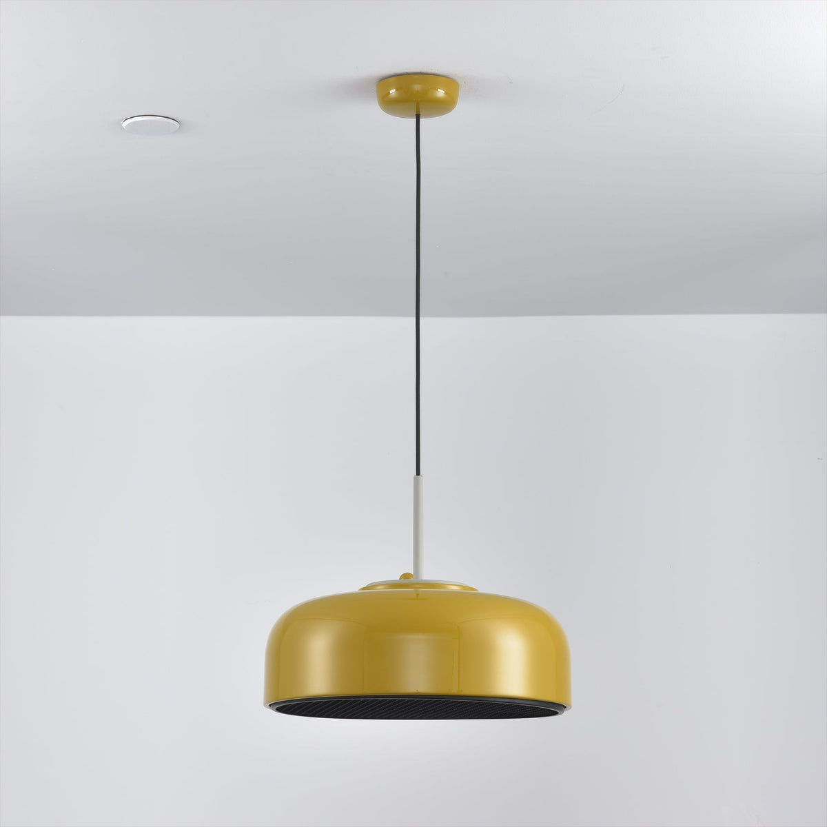 Misha Pendant Light in black, casting a warm glow downwards.