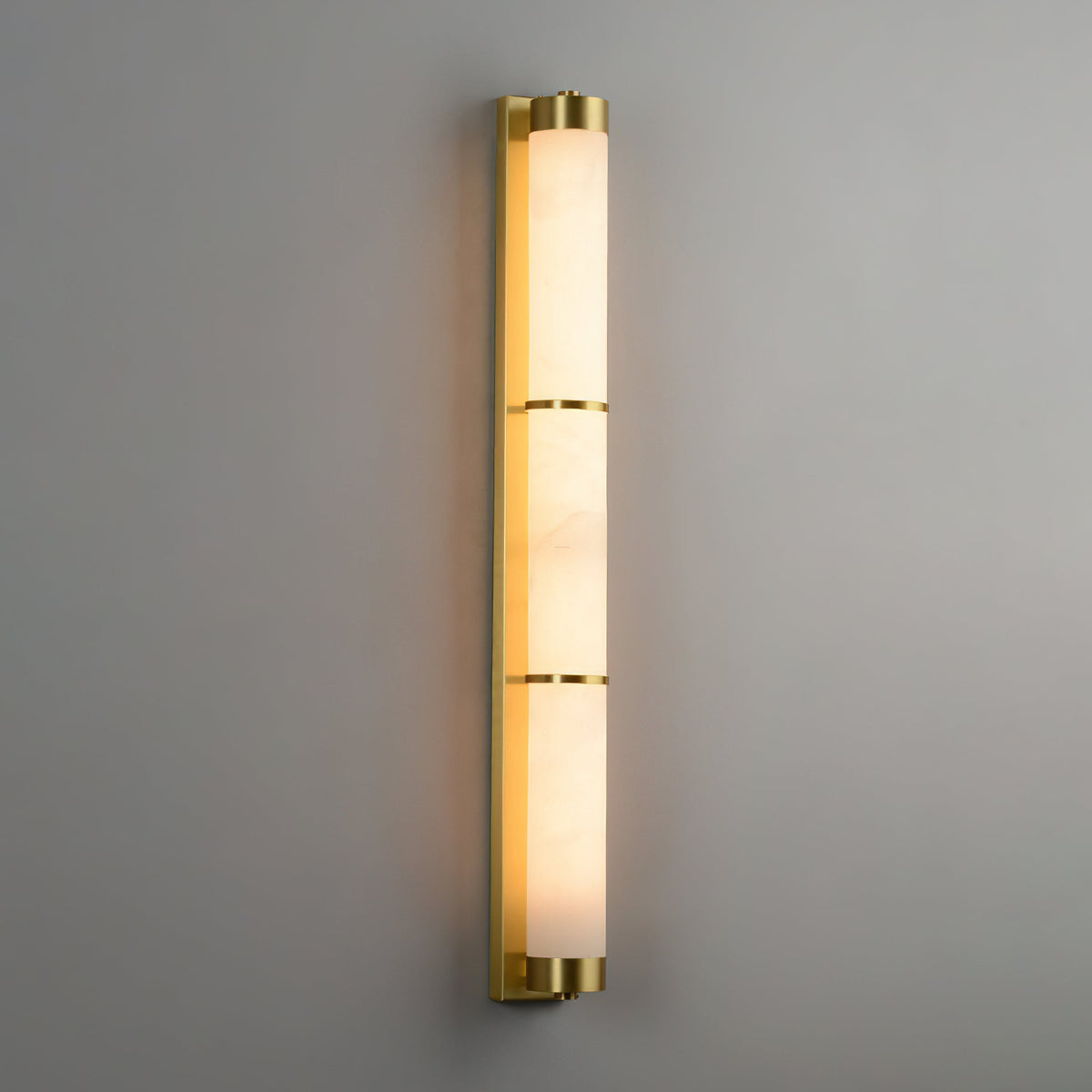 Close-up of the Olmirira Alabaster Wall Light showing alabaster texture and brass bands.