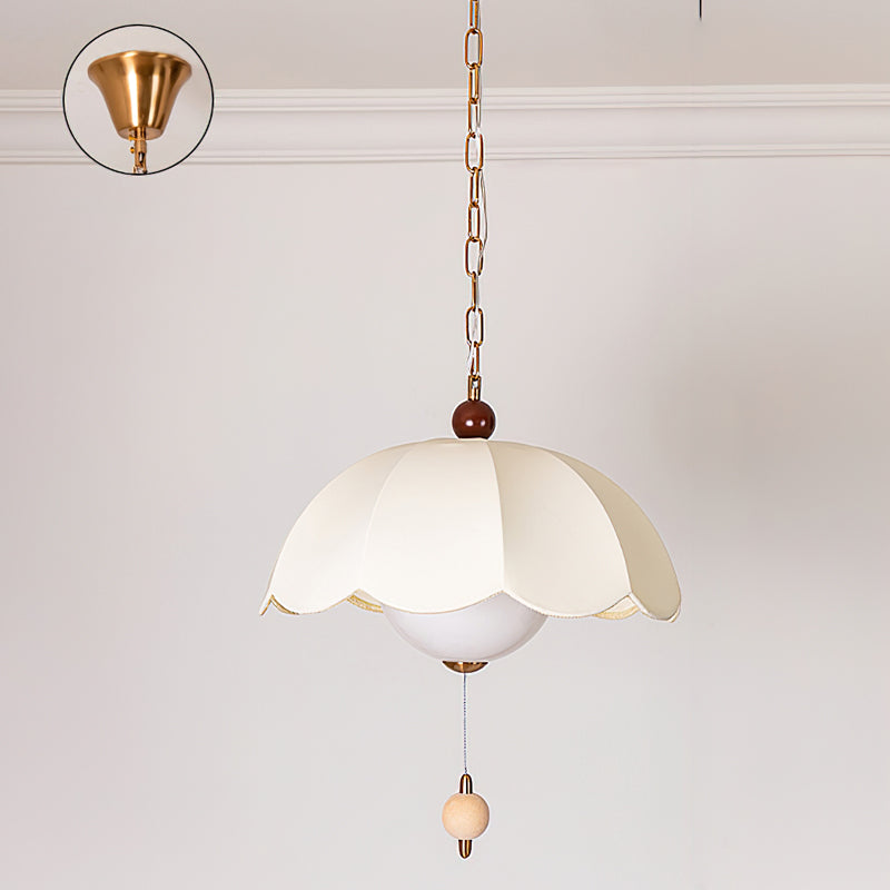 The white fabric shade of the Oriente Pendant Light against a dark wall.