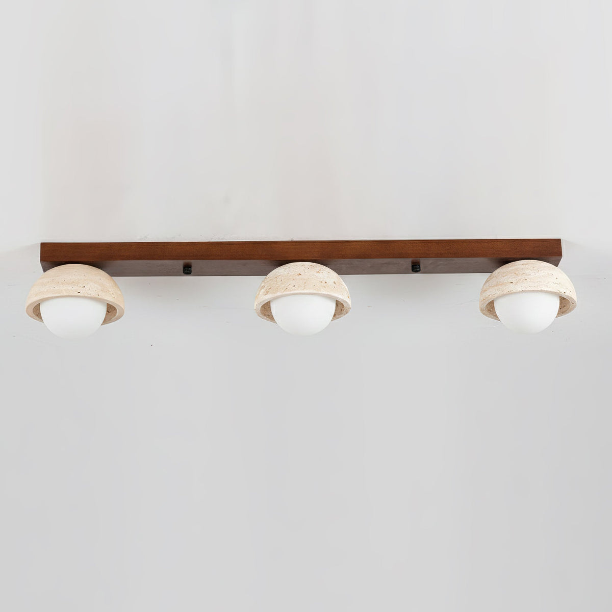 The contrast between the dark walnut wood and the light beige travertine.