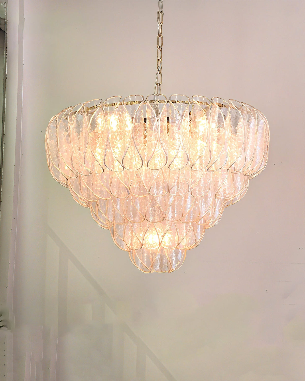 The Poliedri chandelier hanging in a modern living room, casting a warm glow.