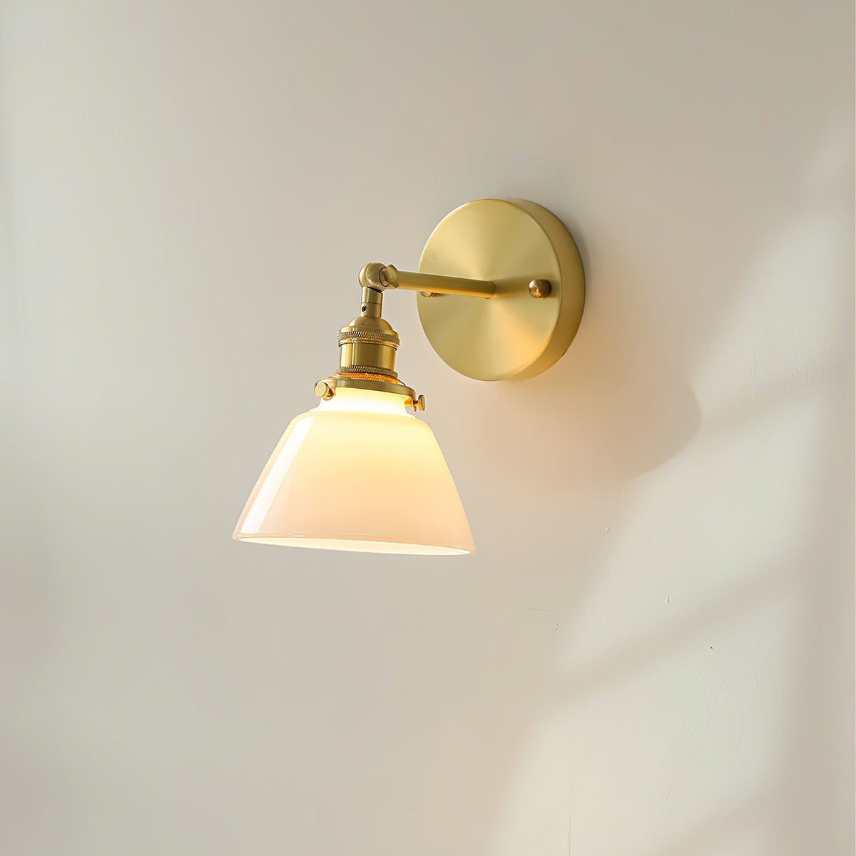 Detail shot of the cone-shaped white glass shade and brass hardware.