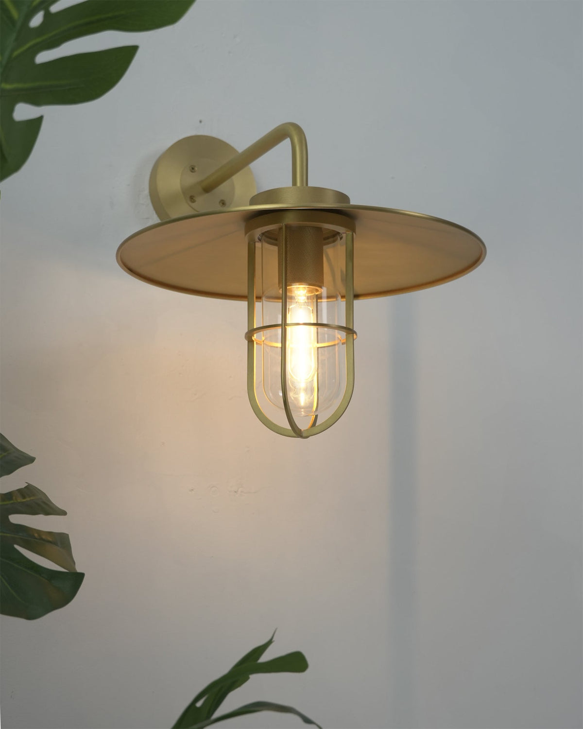 Close-up of the clear glass shade and brass details on the Portree Wall Light.