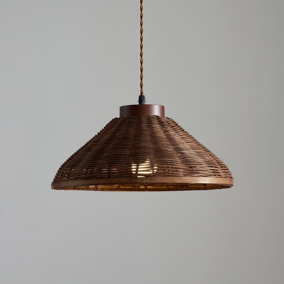 The light diffusion pattern created by the woven rattan shade on a nearby wall.
