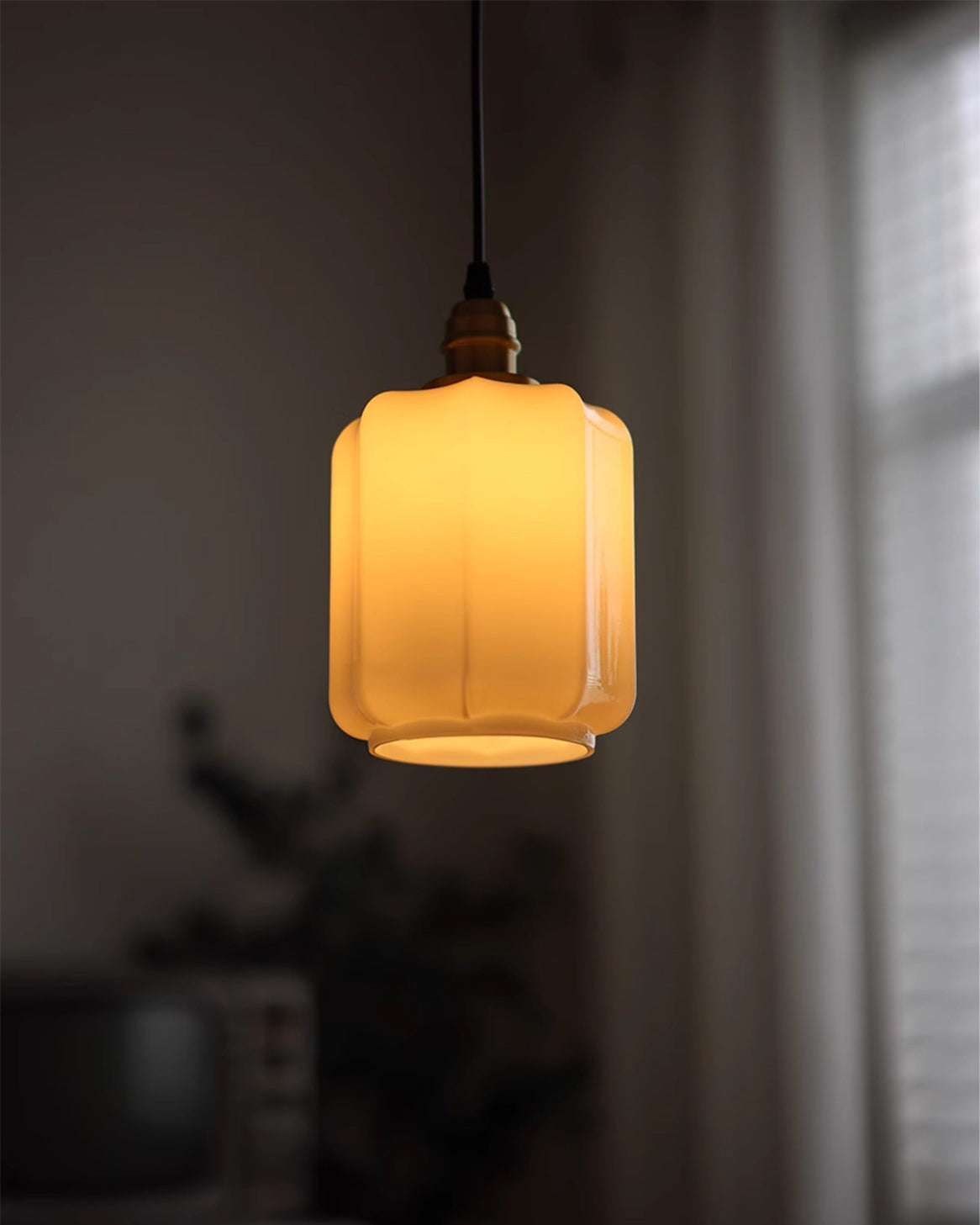 The soft, diffused glow from the Rayburn Pendant Light's white glass shade.