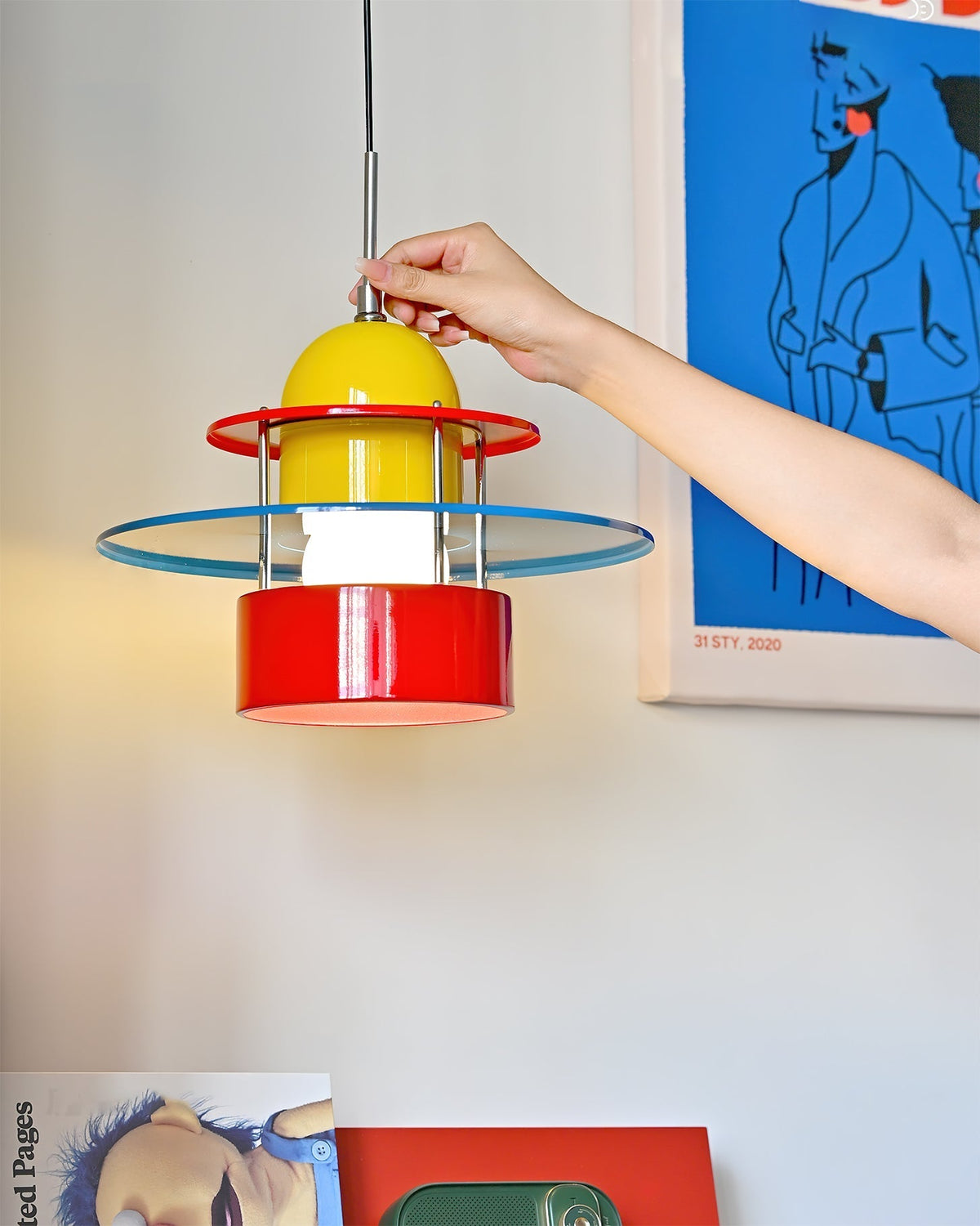 Rolly Pendant Light shown illuminated in a modern room setting.