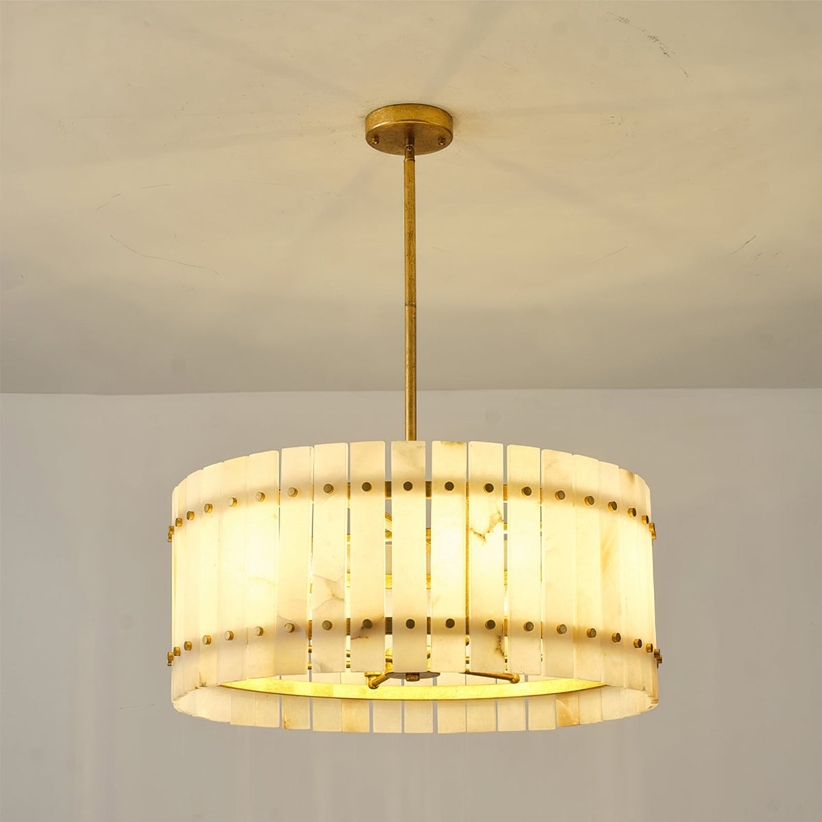 The chandelier installed in a high-ceiling entryway.