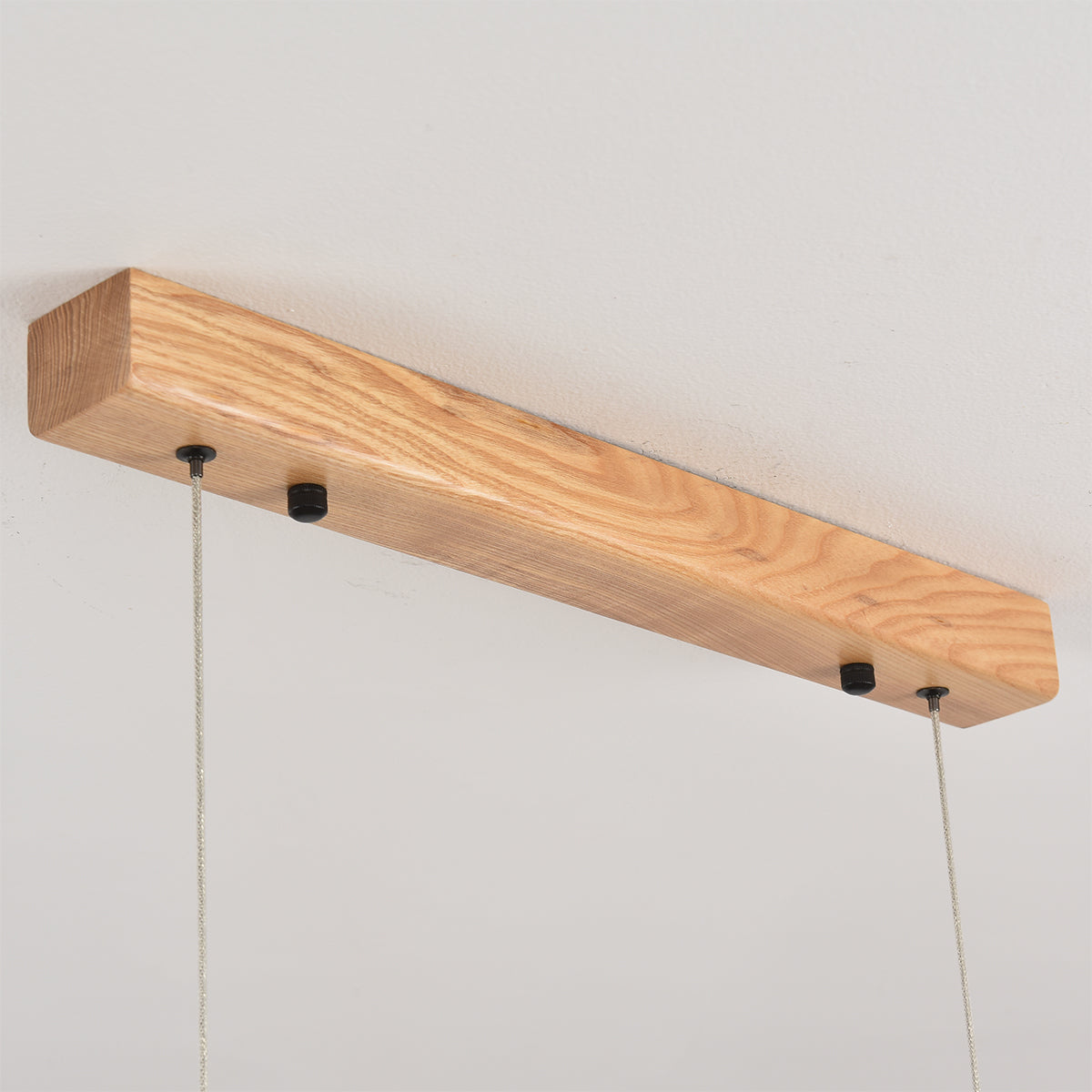 The natural wood finish chandelier over a light wood dining table.